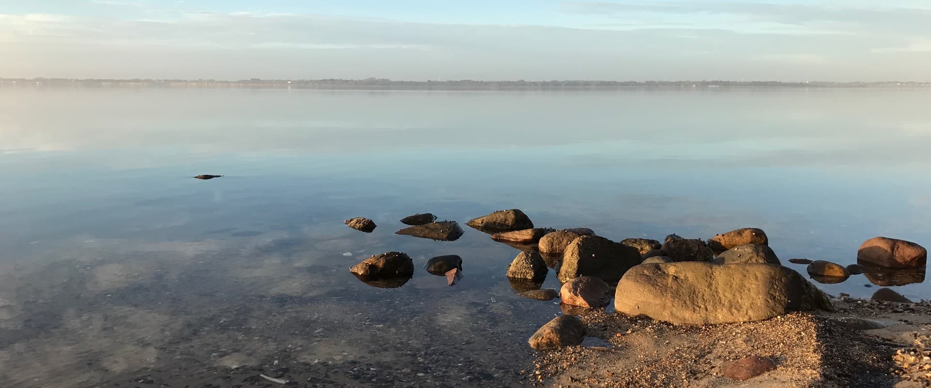 Sten ved fjorden, klart vand